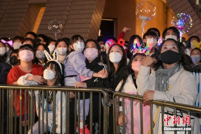 2022年12月31日晚，香港市民在尖沙咀海旁等待倒数活动，迎接2023年。图为有香港市民戴上兔耳朵到尖沙咀海旁等待倒数活动。 中新社记者 陈永诺 摄