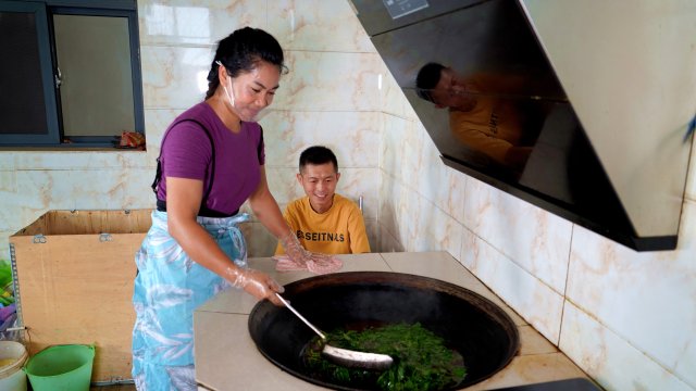 李雪和丈夫在煮染色植物。6月12日摄。.jpg