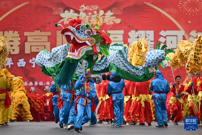 2月19日，在青海省西宁市，舞龙队员在社火巡游活动中表演。新华社记者 张龙 摄