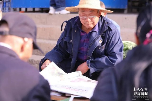 摆摊时，李存德也和大家一起读书看报。（采访传编辑）他们年过七旬，一身书香！来看看大理两位“最美阅读推广人”的故事…….jpg