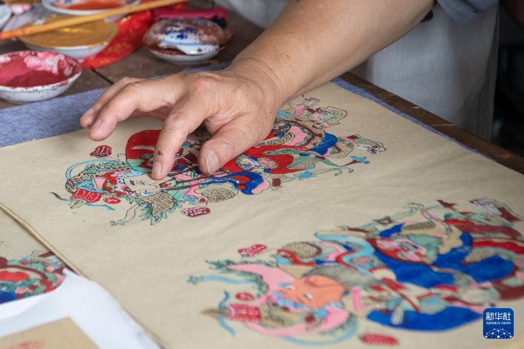 8月10日，梁平木版年画代表性传承人徐家辉在为一幅梁平木版年画“开脸”。