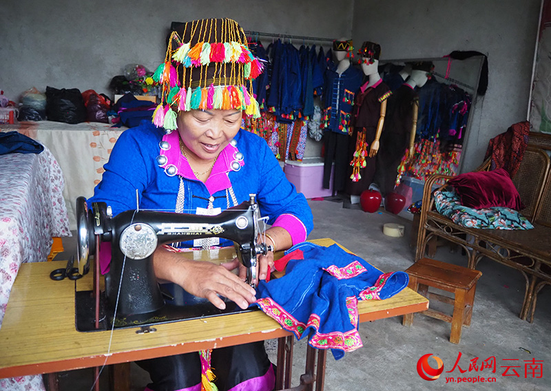 曹先美正在制作阿昌族传统服饰。人民网 王娴摄