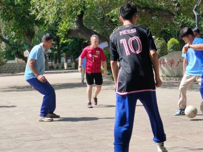 Luke Johnston plays football with some students at an international school in Xinjiang. (Photo provided by the author)