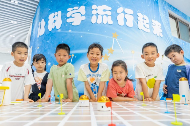 孩子们在操控编程机器人进行对抗赛 孩子们在操控编程机器人进行对抗赛