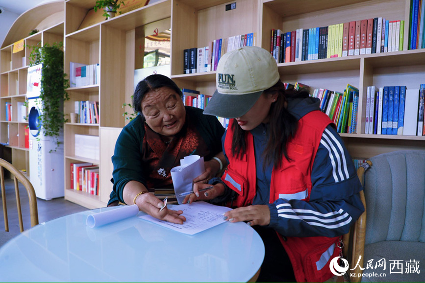 幸福社区的网格员协助老人填写双联户档案表。人民网记者 次仁罗布摄