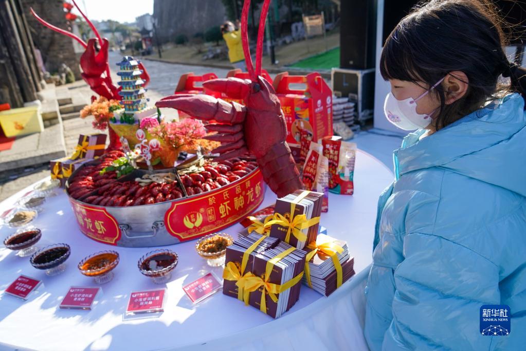 1月10日，在南京老门东历史街区，一名小游客在参观展示的特色龙虾。