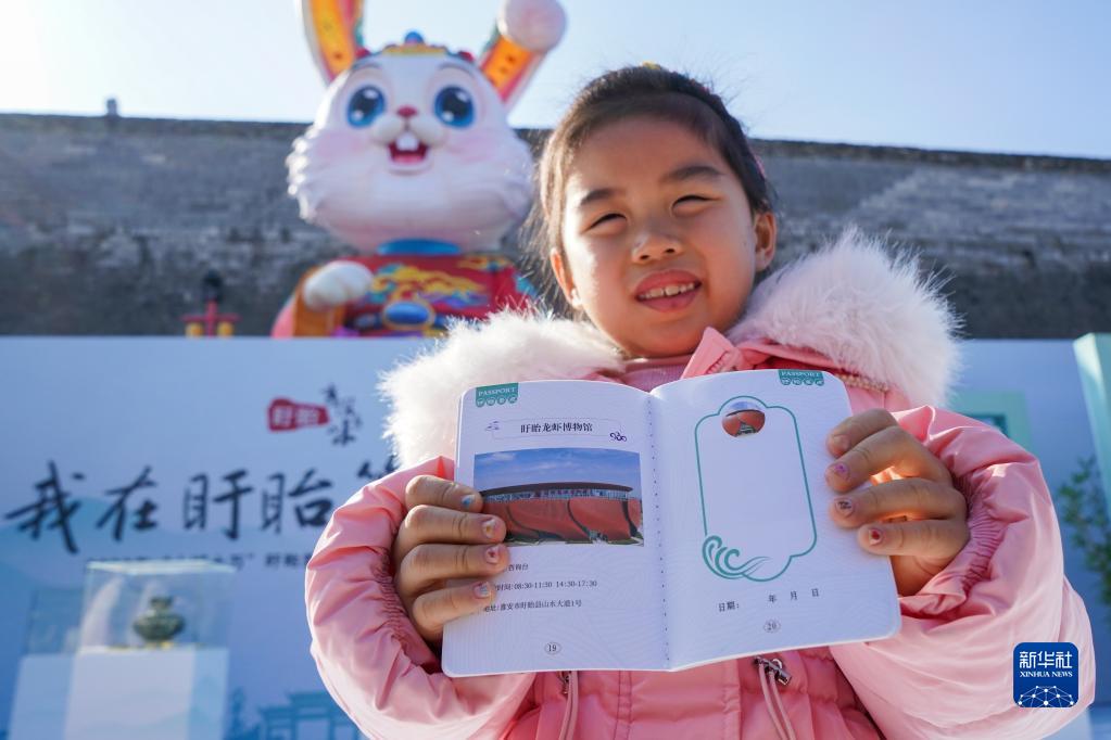 1月10日，在南京老门东历史街区，一名小游客展示领取的“旅游护照”。