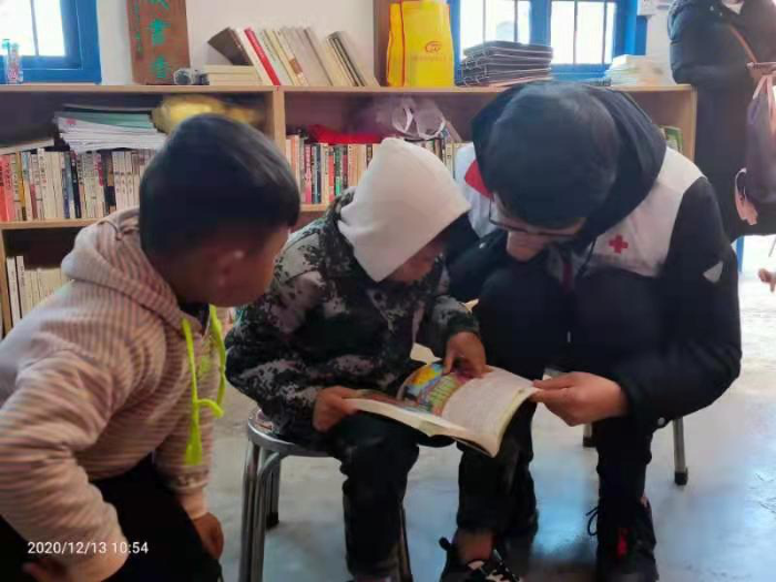 志愿者陈法勝与孩子一起读书