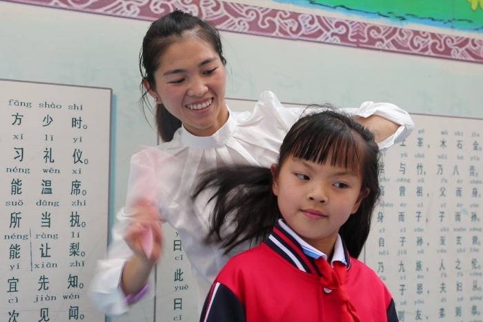 生活老师给学生梳头