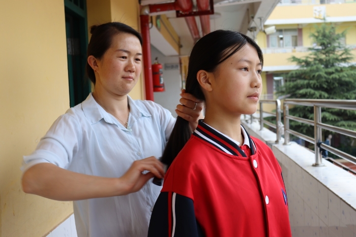 生活老师给学生梳头