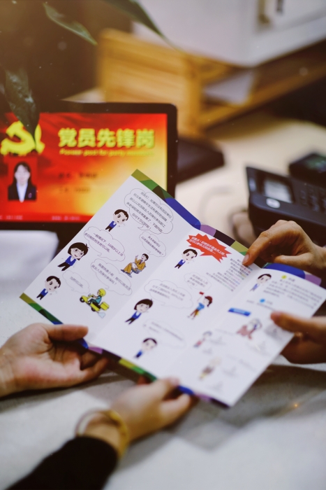 10.社保宣传面对面对，政策解读暖人心——工作人员用宣传册为群众讲社保政策